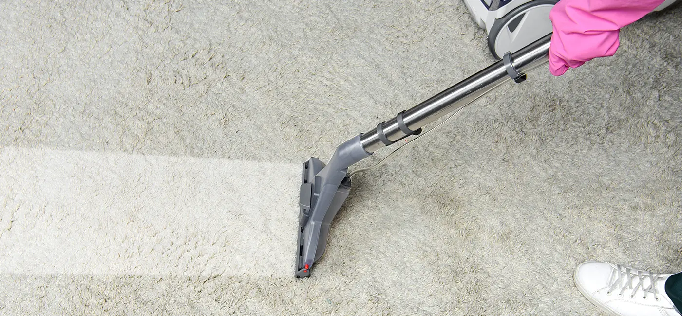 A carpet cleaning wand leaving a bright clean stripe across a soiled carpet