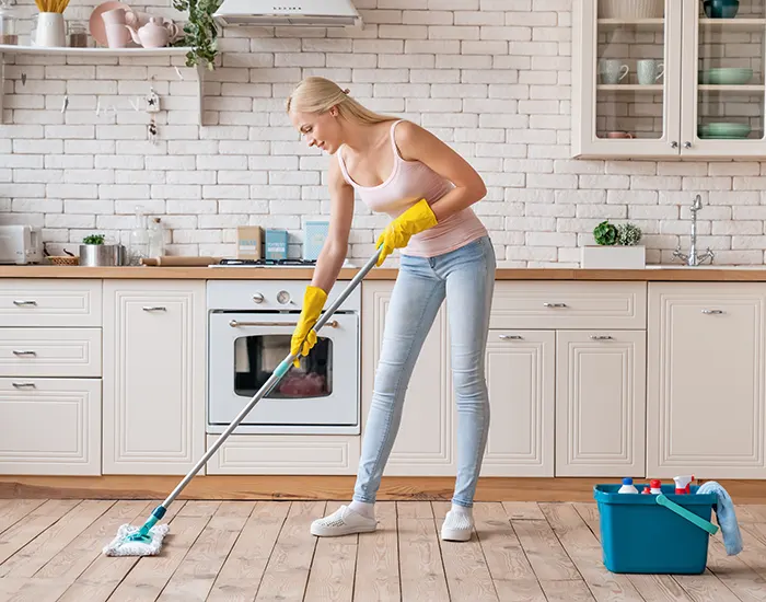 A Choice Cleaning Plus maid mopping a bright kitchen floor