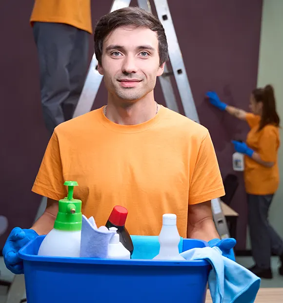 A cleaner holding a box of cleaning tools