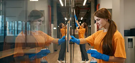 Choice Cleaning Plus crew member cleaning glass partitions