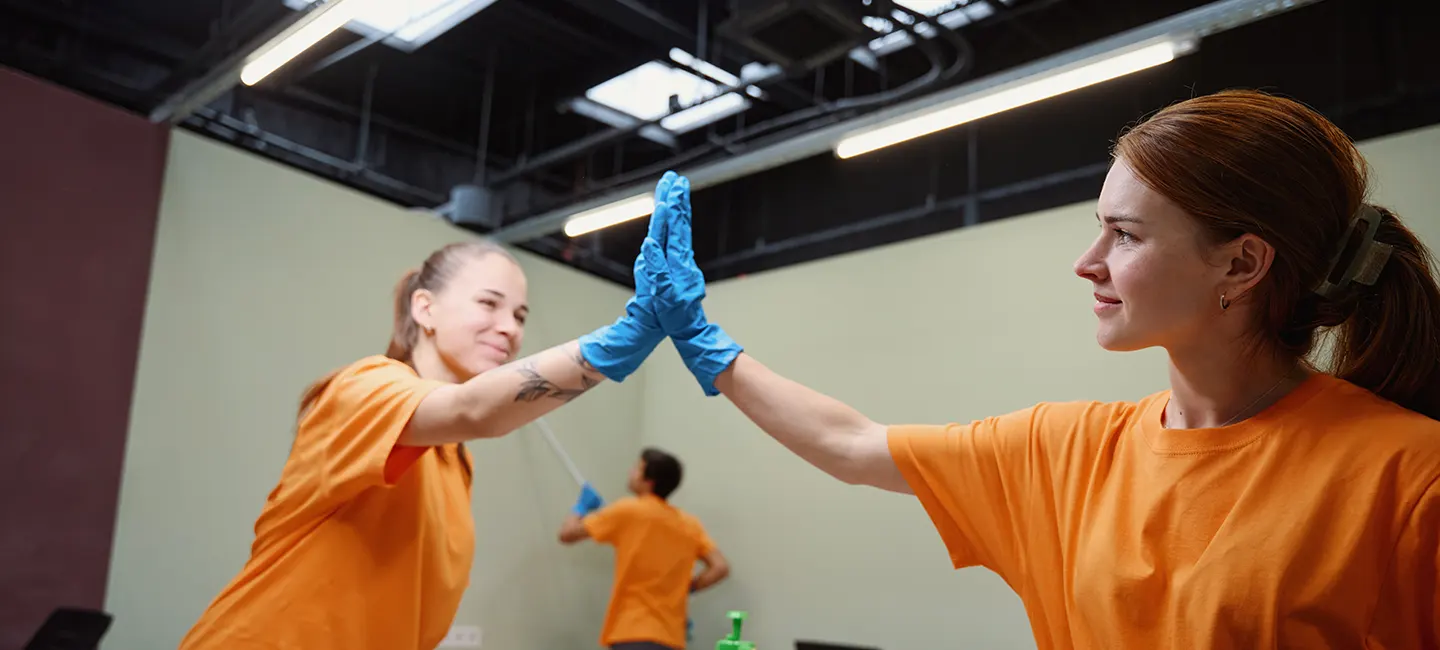 Two Choice Cleaning Plus team members high-fiving after a window cleaning job